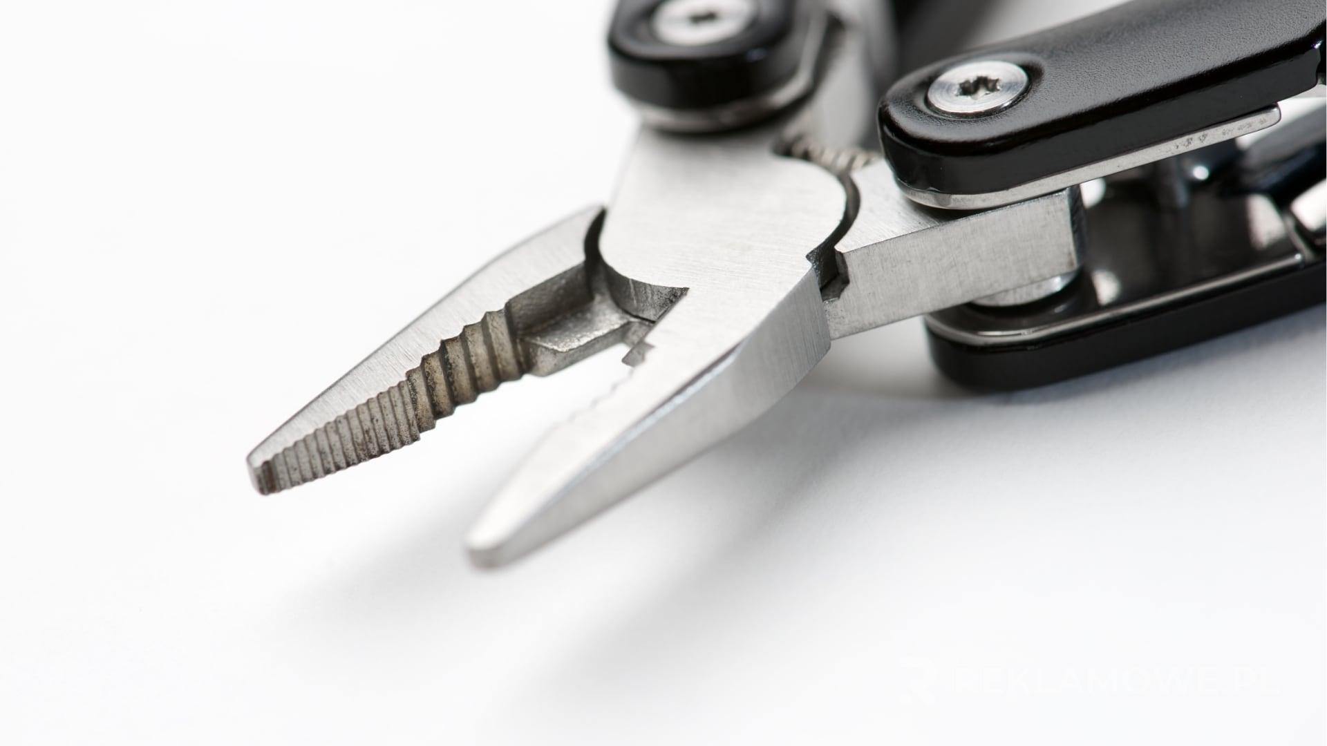 Multitool reklamowy na tle promocyjnych materiałów